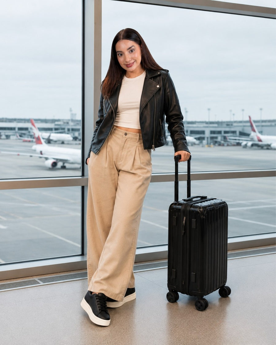 Look con tenis Oreo: chaqueta de cuero y pantalón cargo beige; aeropuerto.