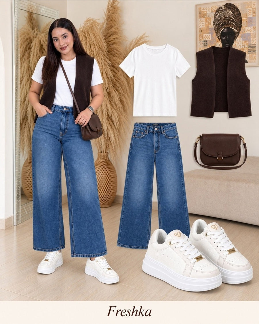Look con tenis Perla: chaleco café, camiseta blanca y jeans.