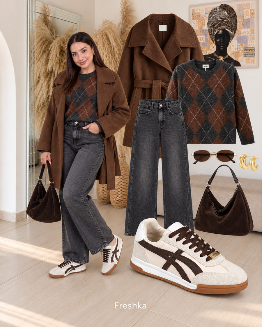 Look de clima fresco con tenis Lux Chocolate, abrigo café, suéter de rombos y jeans grises.