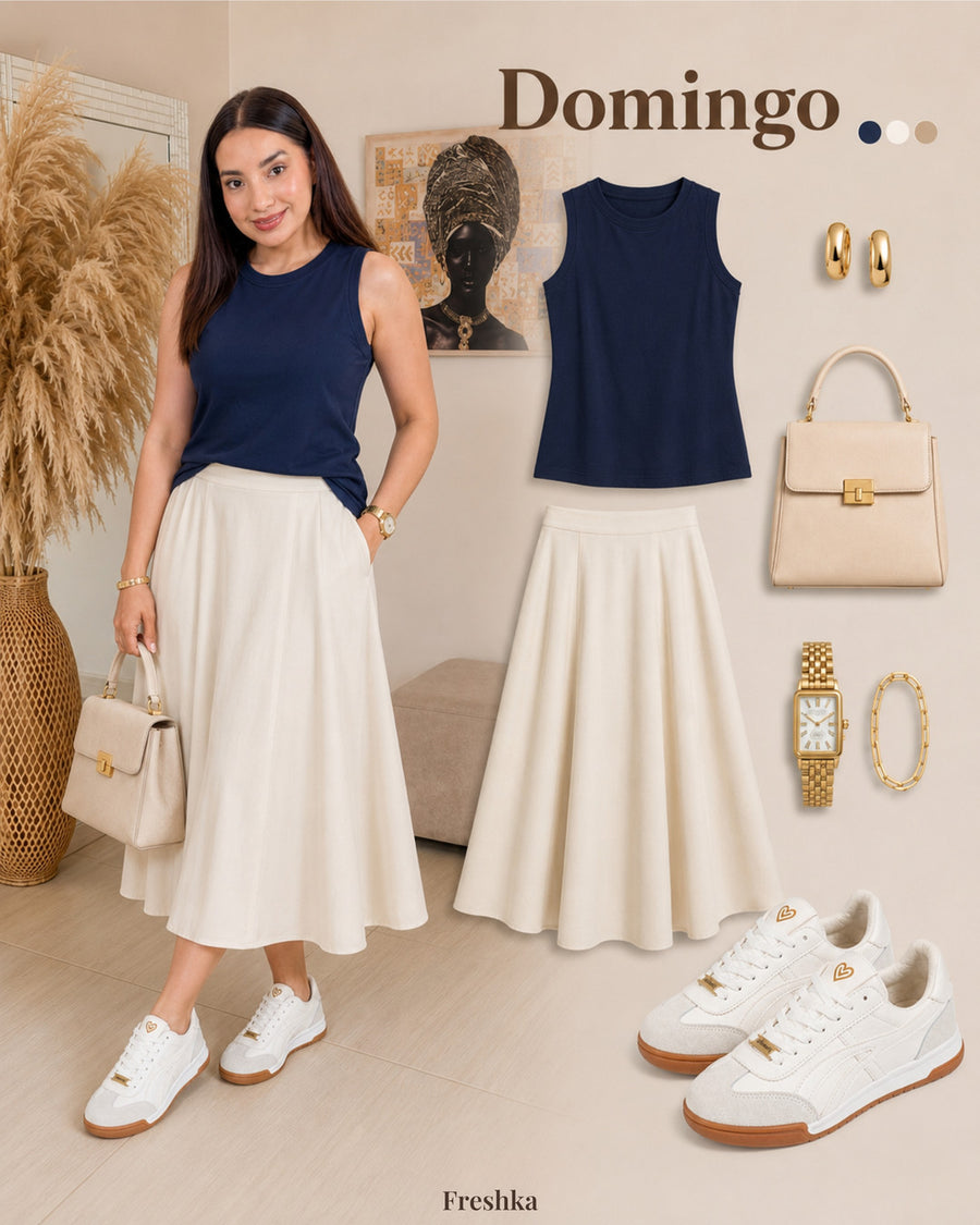 Tenis Lux White con top azul marino sin mangas y falda midi crema.